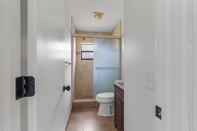 bathroom featuring vanity, an enclosed shower, tile patterned floors, and toilet