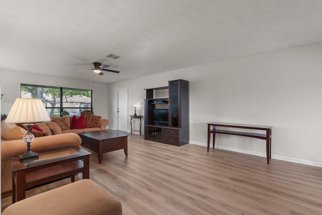 living room featuring ceiling fan, hardwood / wood-style floors, and a textured ceiling