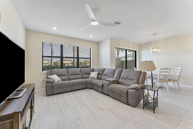 living room with ceiling fan with notable chandelier