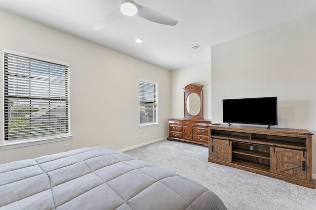 carpeted bedroom featuring multiple windows and ceiling fan