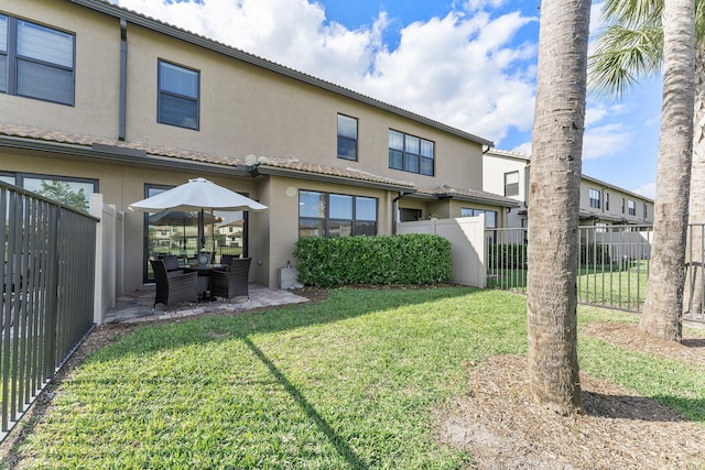 back of property with a patio and a lawn