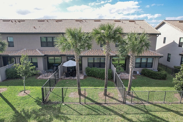 rear view of house with a yard and a patio