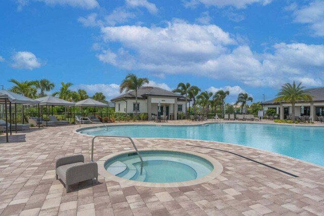 view of swimming pool with a water view and a patio area