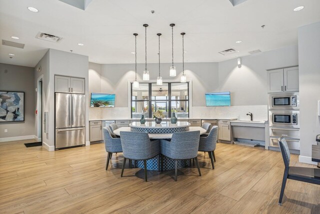 dining area featuring a tray ceiling, light hardwood / wood-style floors, and a wealth of natural light