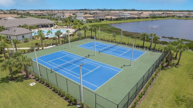 view of tennis court with a water view