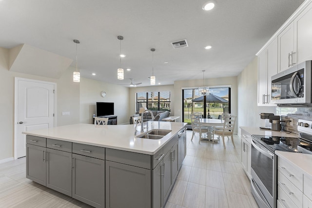 kitchen with gray cabinets, decorative light fixtures, sink, white cabinets, and stainless steel appliances