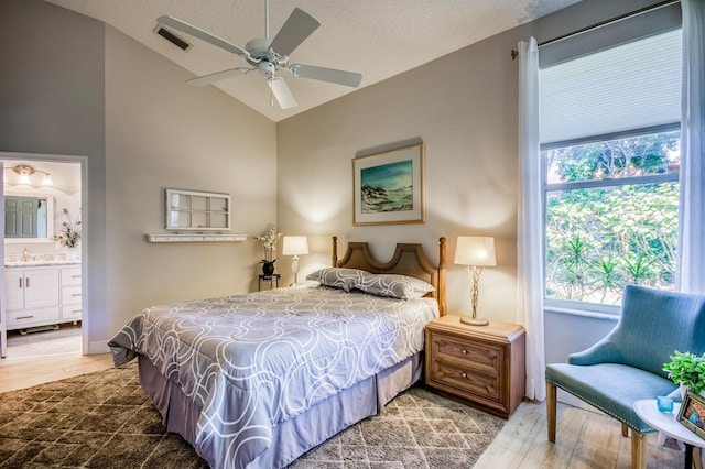 bedroom featuring multiple windows, lofted ceiling, and hardwood / wood-style floors