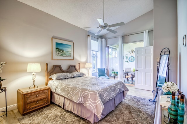 bedroom with vaulted ceiling, wood-type flooring, access to exterior, ceiling fan, and a textured ceiling