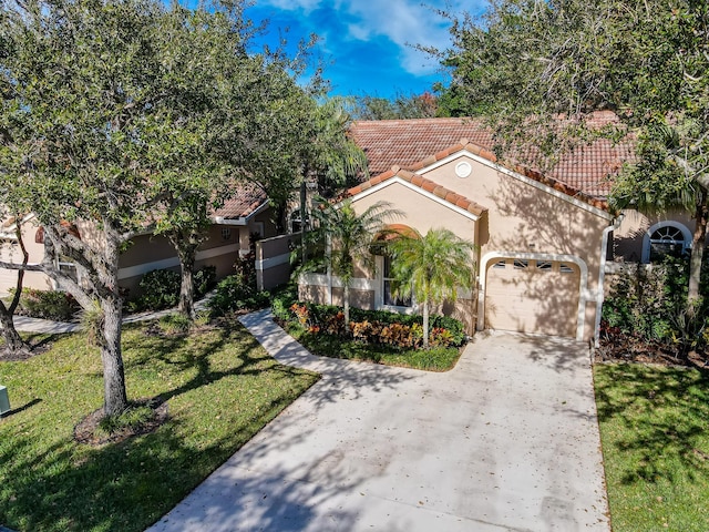 mediterranean / spanish-style house featuring a garage and a front yard