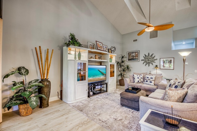 living room with ceiling fan, high vaulted ceiling, and light wood-type flooring