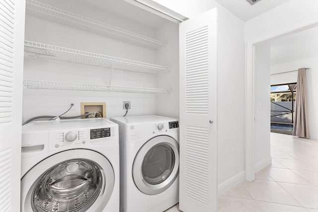 laundry room with light tile patterned flooring and independent washer and dryer