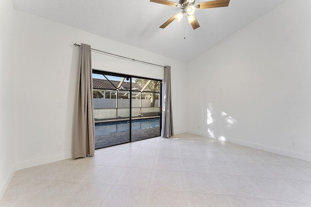 tiled empty room with vaulted ceiling and ceiling fan