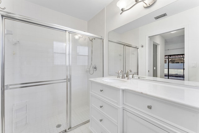 bathroom featuring vanity and a shower with shower door