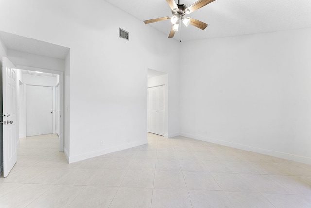 tiled empty room with ceiling fan