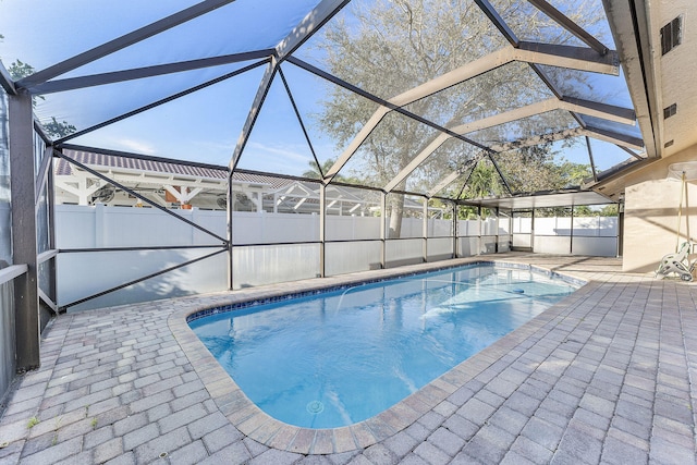 view of swimming pool featuring a lanai and a patio