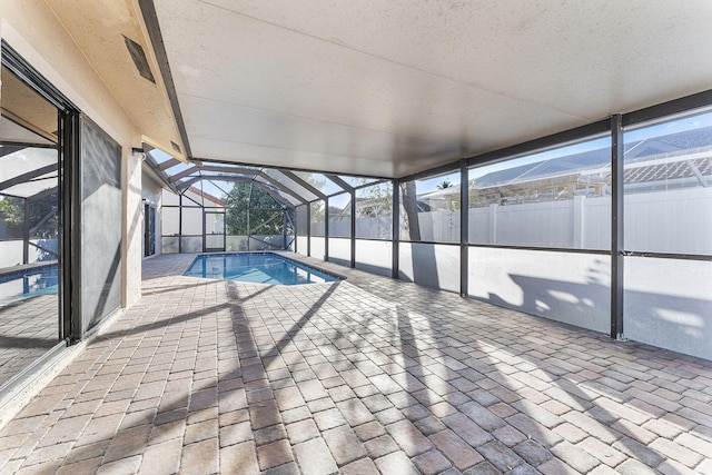 view of swimming pool with glass enclosure and a patio area