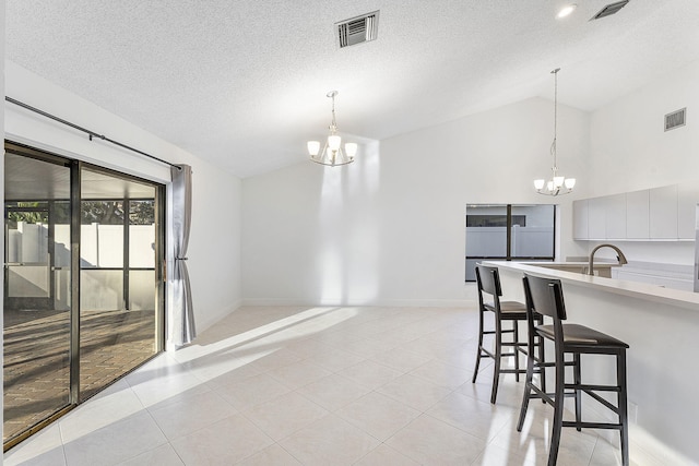 interior space featuring a kitchen bar, decorative light fixtures, and a chandelier