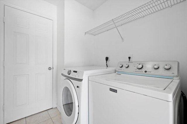 washroom featuring separate washer and dryer and light tile patterned flooring