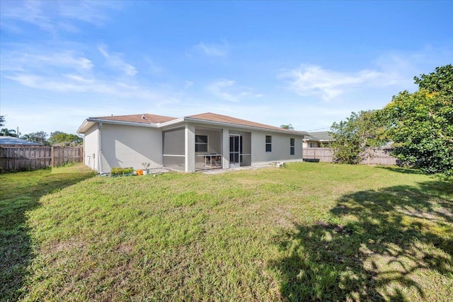 back of property featuring a yard and a sunroom