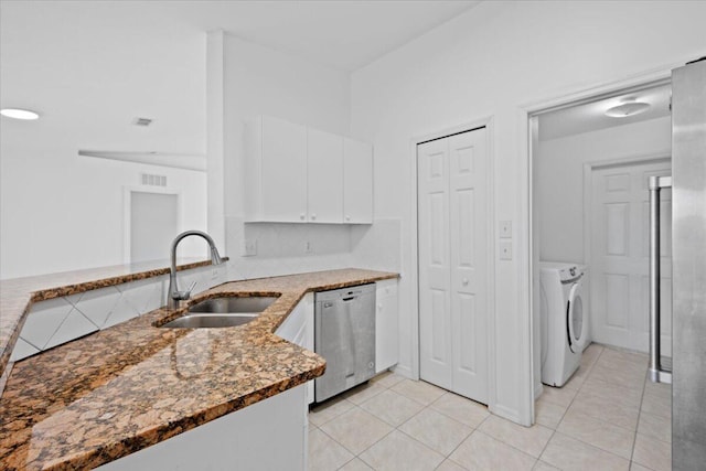 kitchen featuring sink, separate washer and dryer, dishwasher, dark stone counters, and white cabinets