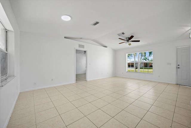 spare room with light tile patterned floors, vaulted ceiling, and ceiling fan