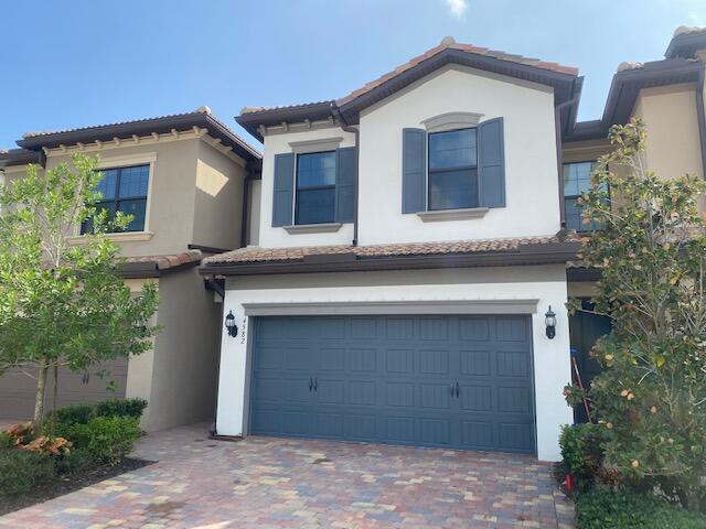 4582 San Fratello Cir, Lake Worth, FL 33467 - townhome / multi-family property featuring stucco siding, an attached garage, driveway, and a tiled roof