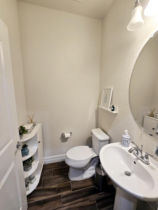 4582 San Fratello Cir, Lake Worth, FL 33467 - bathroom featuring toilet, wood finish floors, a sink, and baseboards