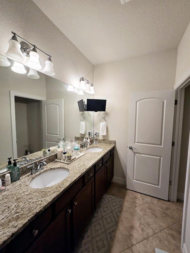 4582 San Fratello Cir, Lake Worth, FL 33467 - bathroom with double vanity, baseboards, tile patterned flooring, and a textured ceiling