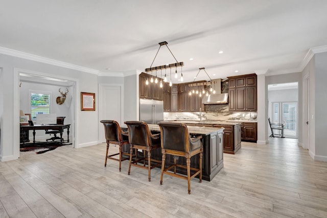 kitchen featuring a kitchen island, pendant lighting, tasteful backsplash, stainless steel built in refrigerator, and light stone counters