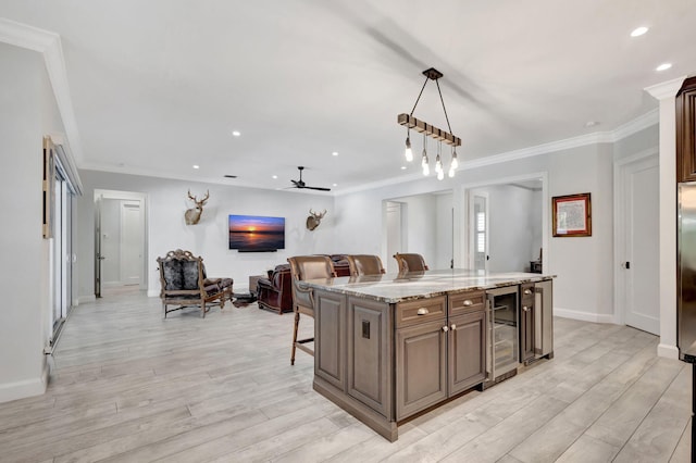 kitchen with hanging light fixtures, a center island, a kitchen bar, and light hardwood / wood-style flooring