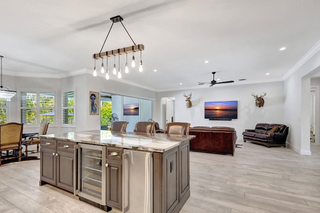 kitchen featuring refrigerator, beverage cooler, decorative light fixtures, and a kitchen island