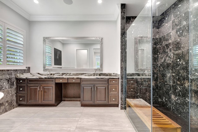 bathroom featuring ornamental molding, tiled shower, vanity, and a healthy amount of sunlight