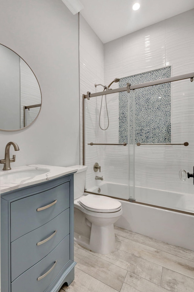 full bathroom with vanity, enclosed tub / shower combo, and toilet