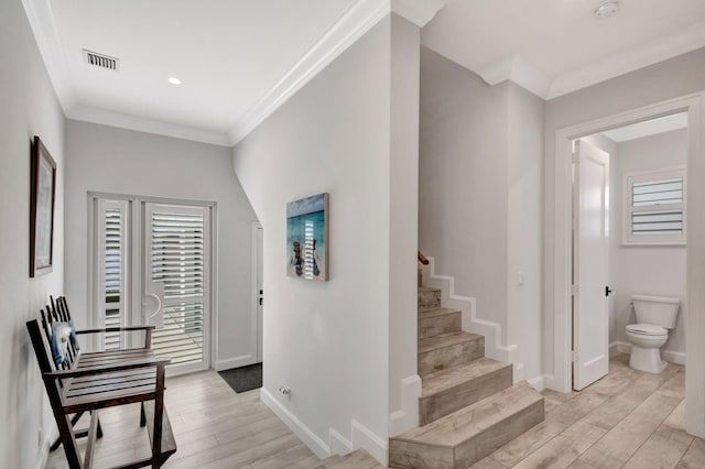 hallway featuring ornamental molding, plenty of natural light, and light hardwood / wood-style floors