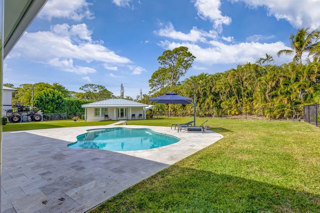 view of pool with a patio area and a lawn