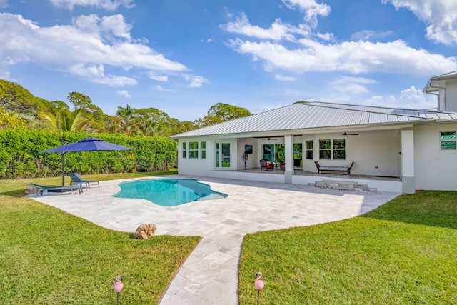 view of swimming pool featuring ceiling fan, a patio area, and a lawn