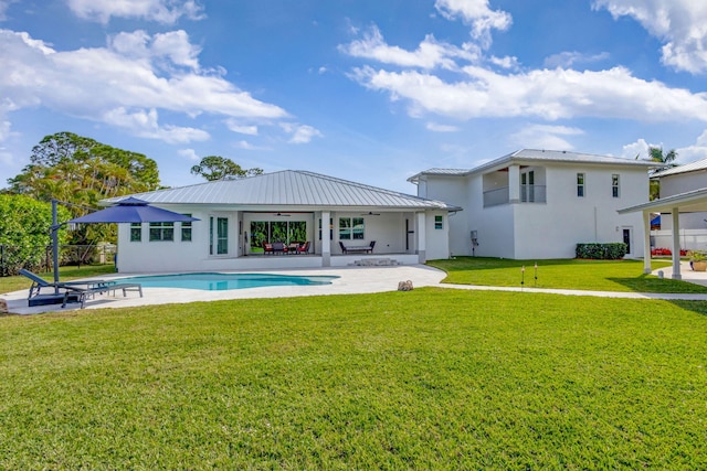 back of house with a yard and a patio