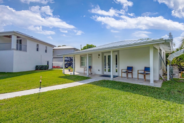 view of front of home with a patio and a front lawn