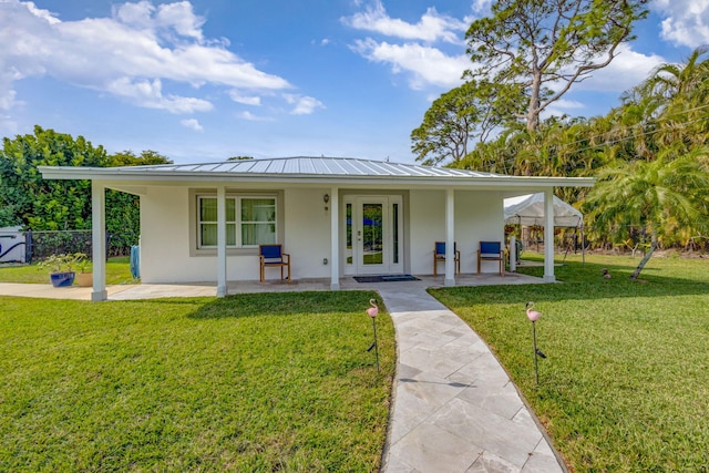 back of property featuring french doors and a lawn