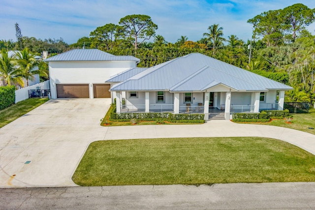 view of front of property featuring a garage, covered porch, and a front lawn