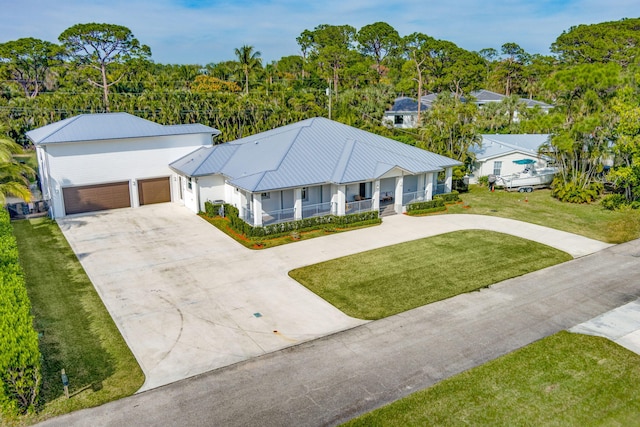 view of front of home with a porch, a garage, and a front yard