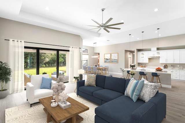 living area with a ceiling fan, recessed lighting, light wood-style floors, and baseboards