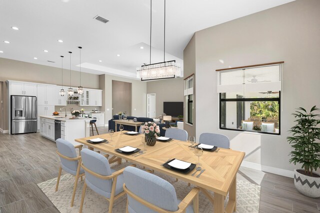 office space featuring a raised ceiling, ceiling fan, and light hardwood / wood-style floors