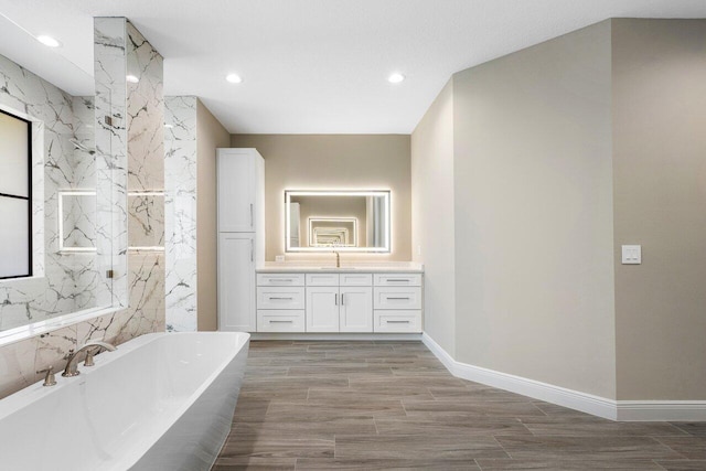 bathroom featuring vanity and a tub to relax in