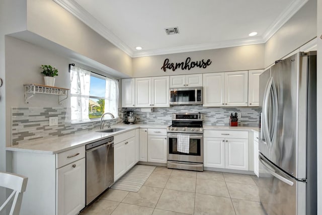 kitchen featuring sink, crown molding, light tile patterned floors, stainless steel appliances, and white cabinets