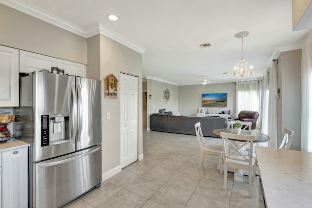 kitchen featuring white cabinetry, decorative light fixtures, ornamental molding, and stainless steel refrigerator with ice dispenser