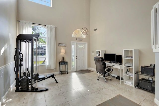 office featuring light tile patterned floors, a chandelier, and a high ceiling