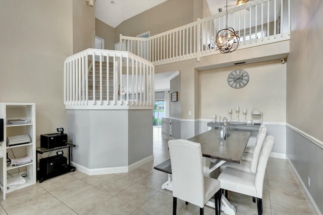 tiled dining room with an inviting chandelier and a high ceiling