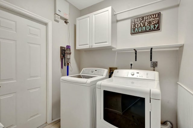 washroom with cabinets and washing machine and clothes dryer