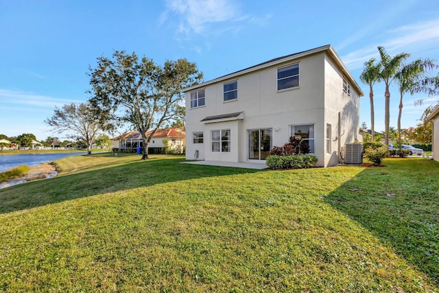 back of property with central AC unit and a yard